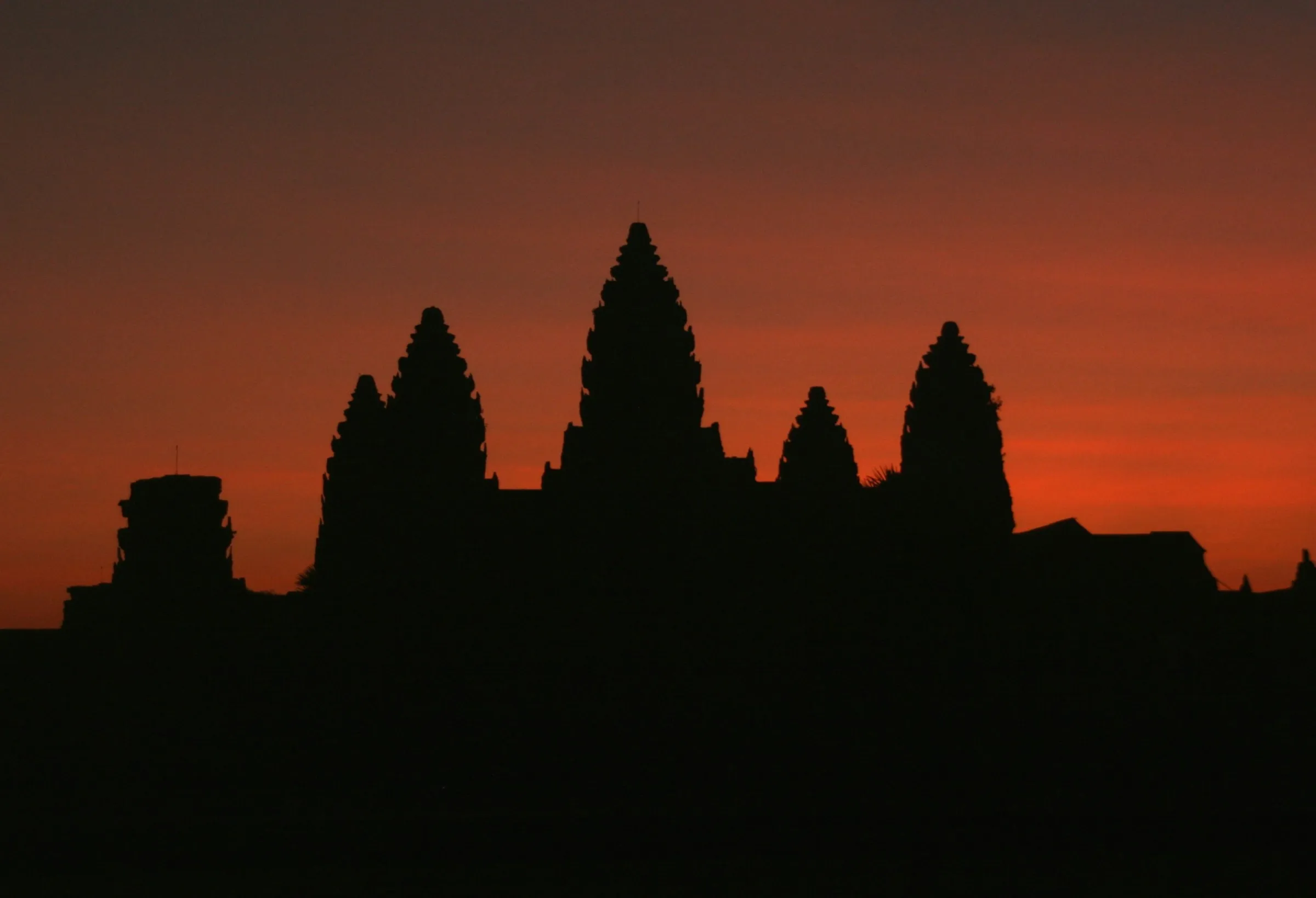 The towers of Angkor Wat silhouetted against a fiery sunrise